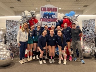 A large group of volleyball players posing for a team photo with coaches.